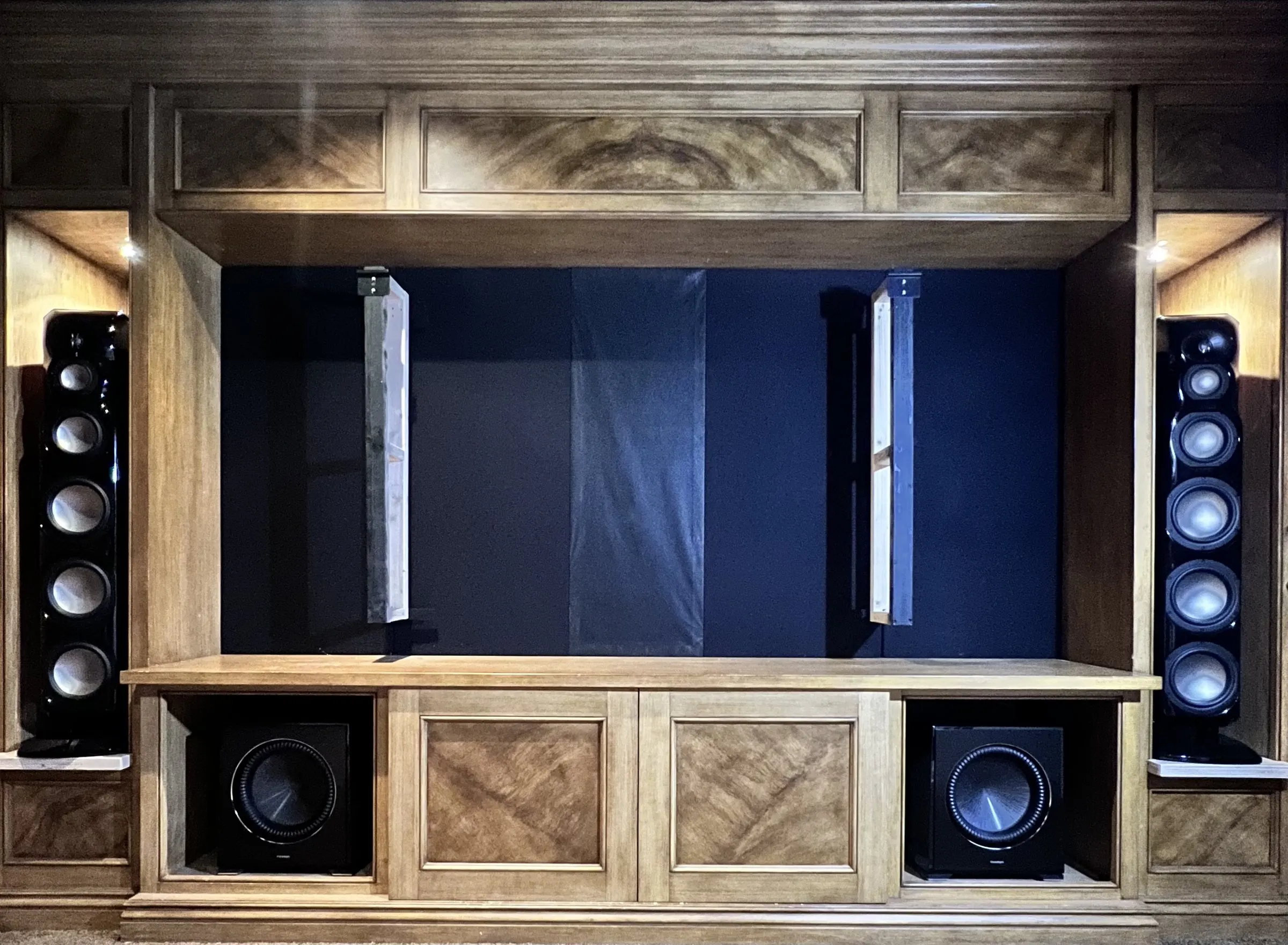 Custom cabinetry with tower speakers and subwoofers, center panel closed