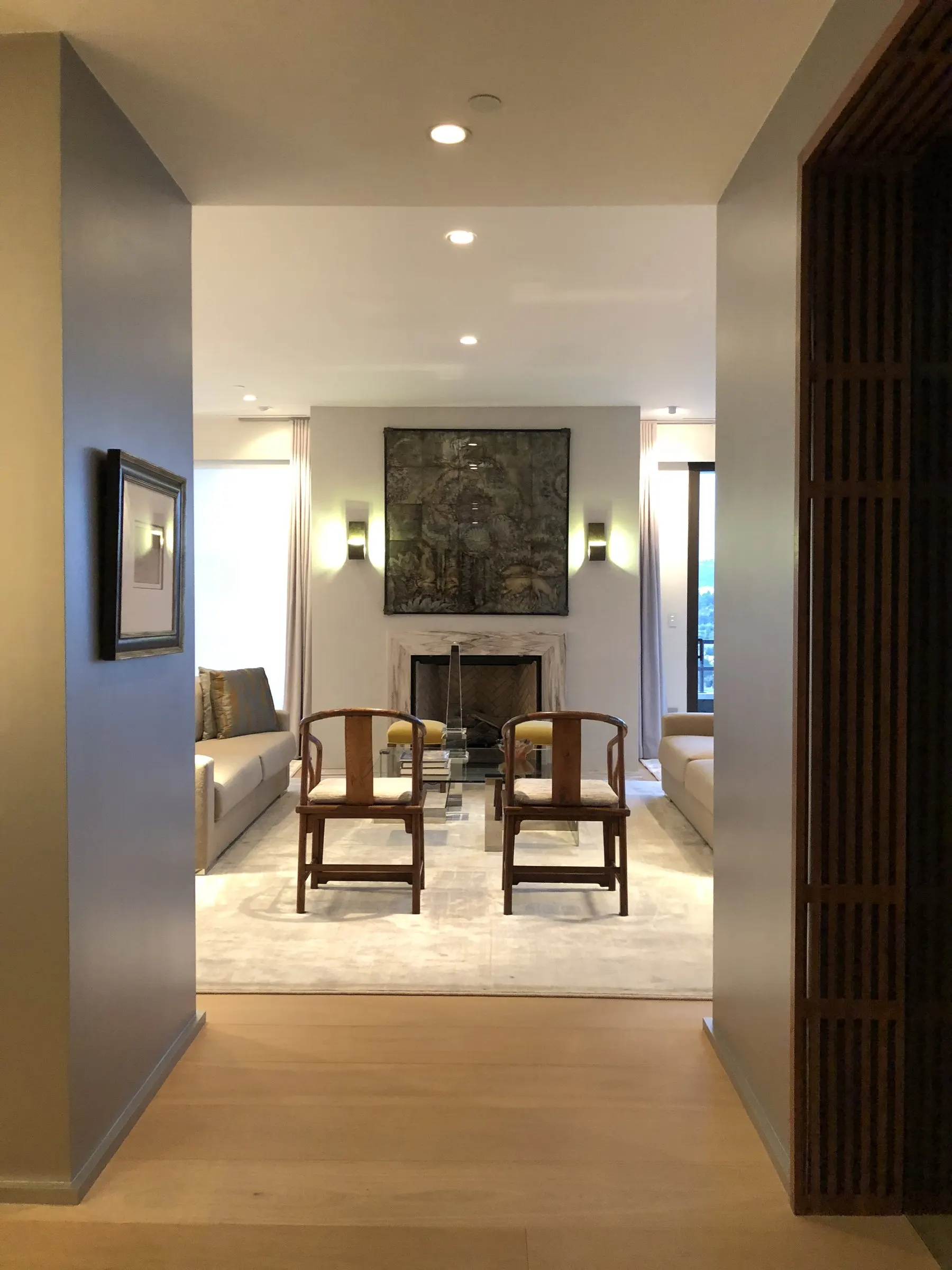 Entry looking into a living room, lit with recessed and accent lighting