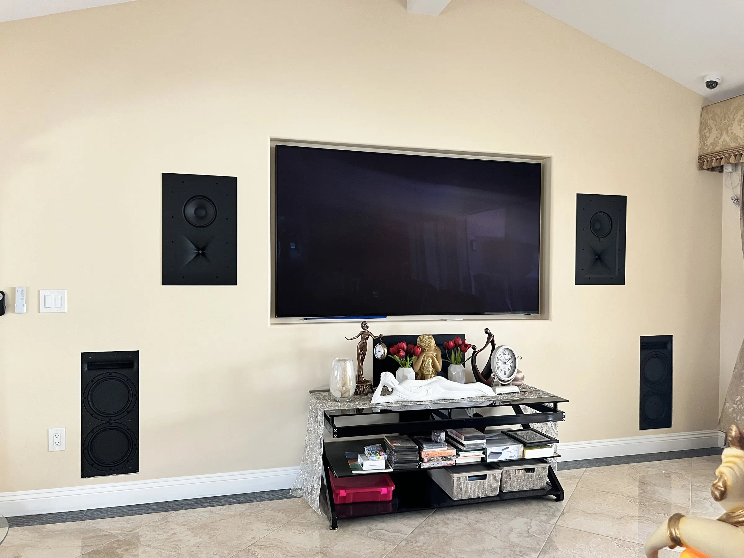 Display flanked by in-wall speakers and in-wall subwoofers