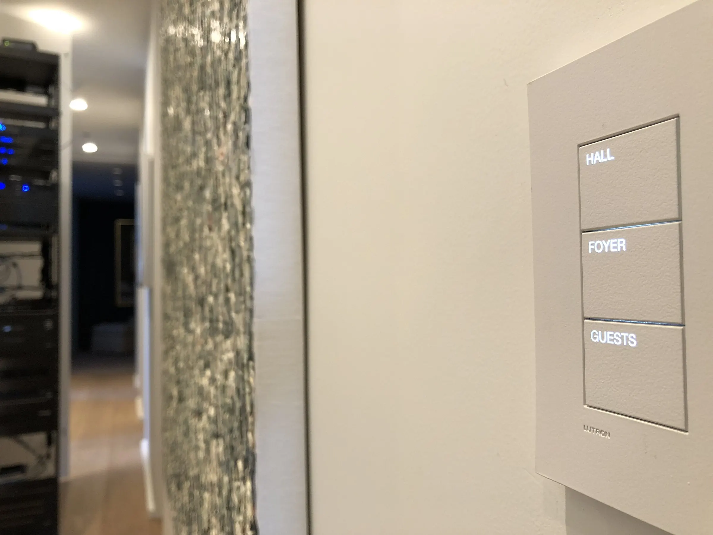 Engraved keypad labeled Hall, Foyer, and Guests beside a textured wall