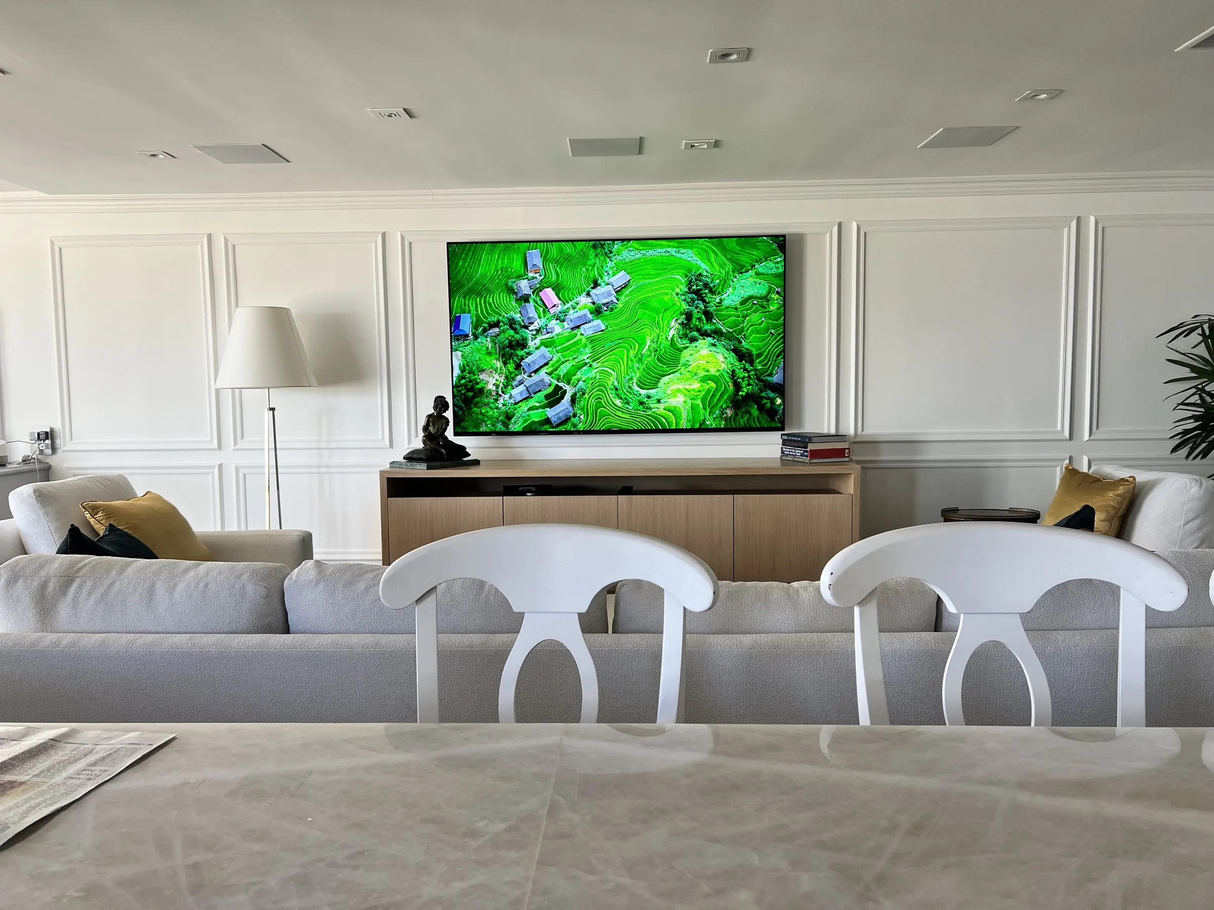 Formal living room with a wall-mounted television above a low credenza, in-ceiling speakers