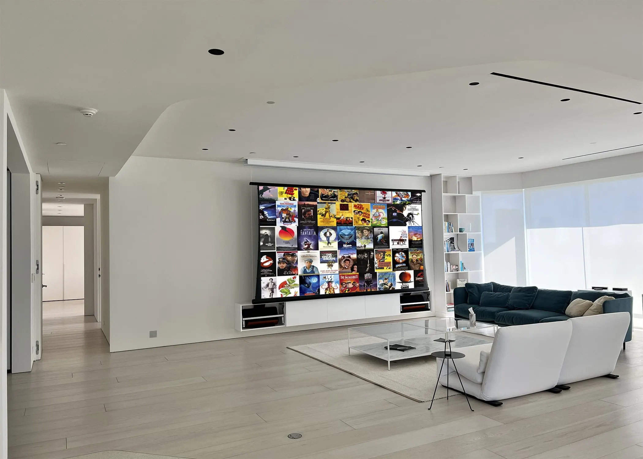 Open living room with a white sectional and a lowered projection screen