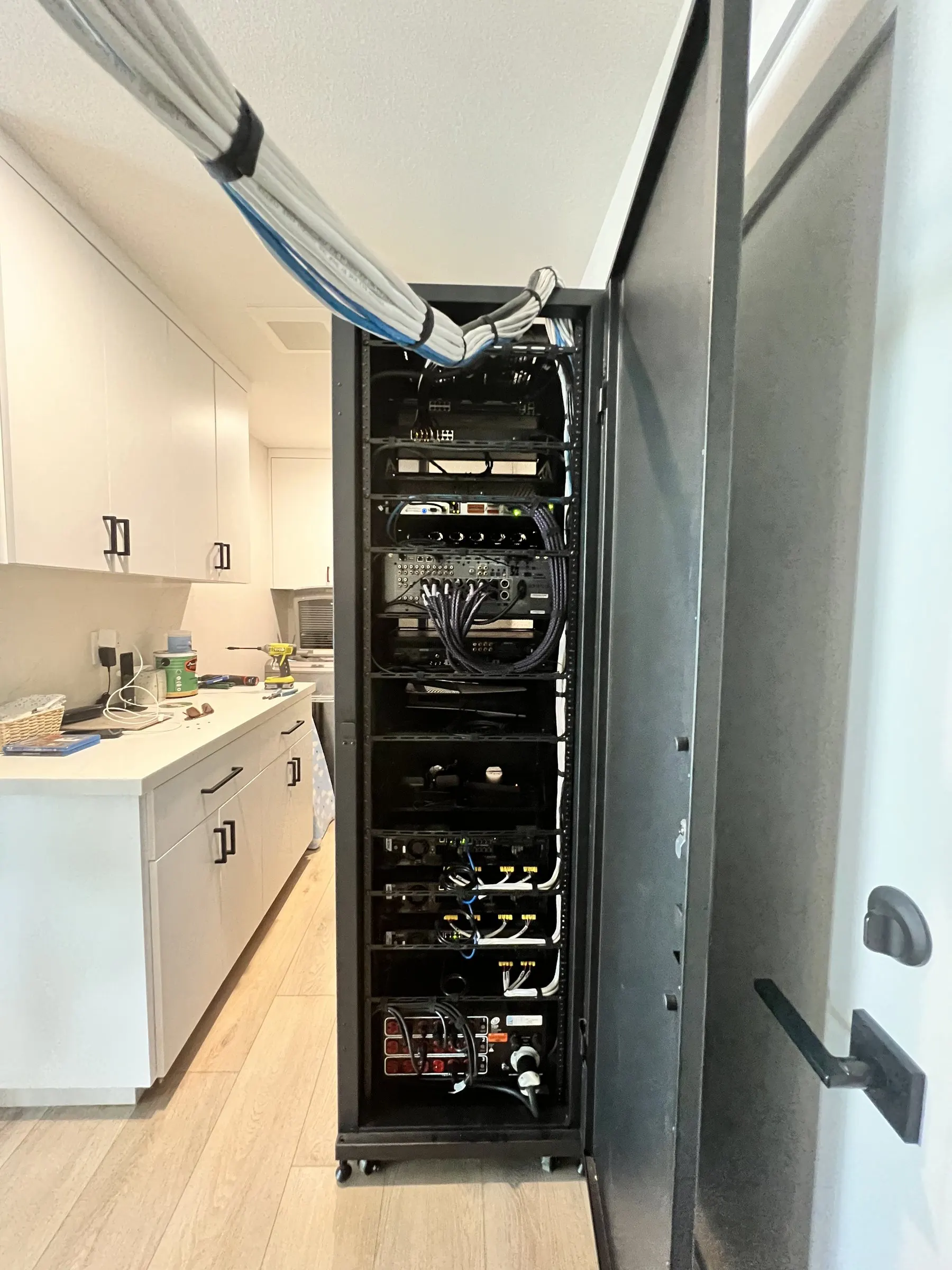 Freestanding equipment rack with a neatly bundled cable run entering from the ceiling and tidy wiring inside