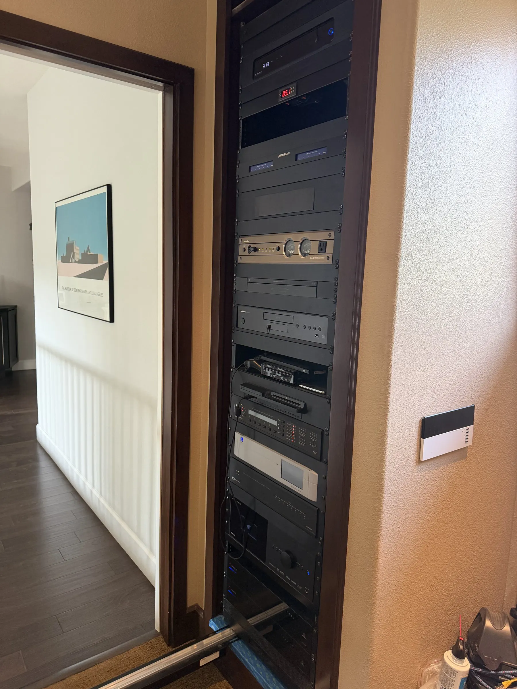 Equipment rack inside a closet with a keypad on the adjacent wall