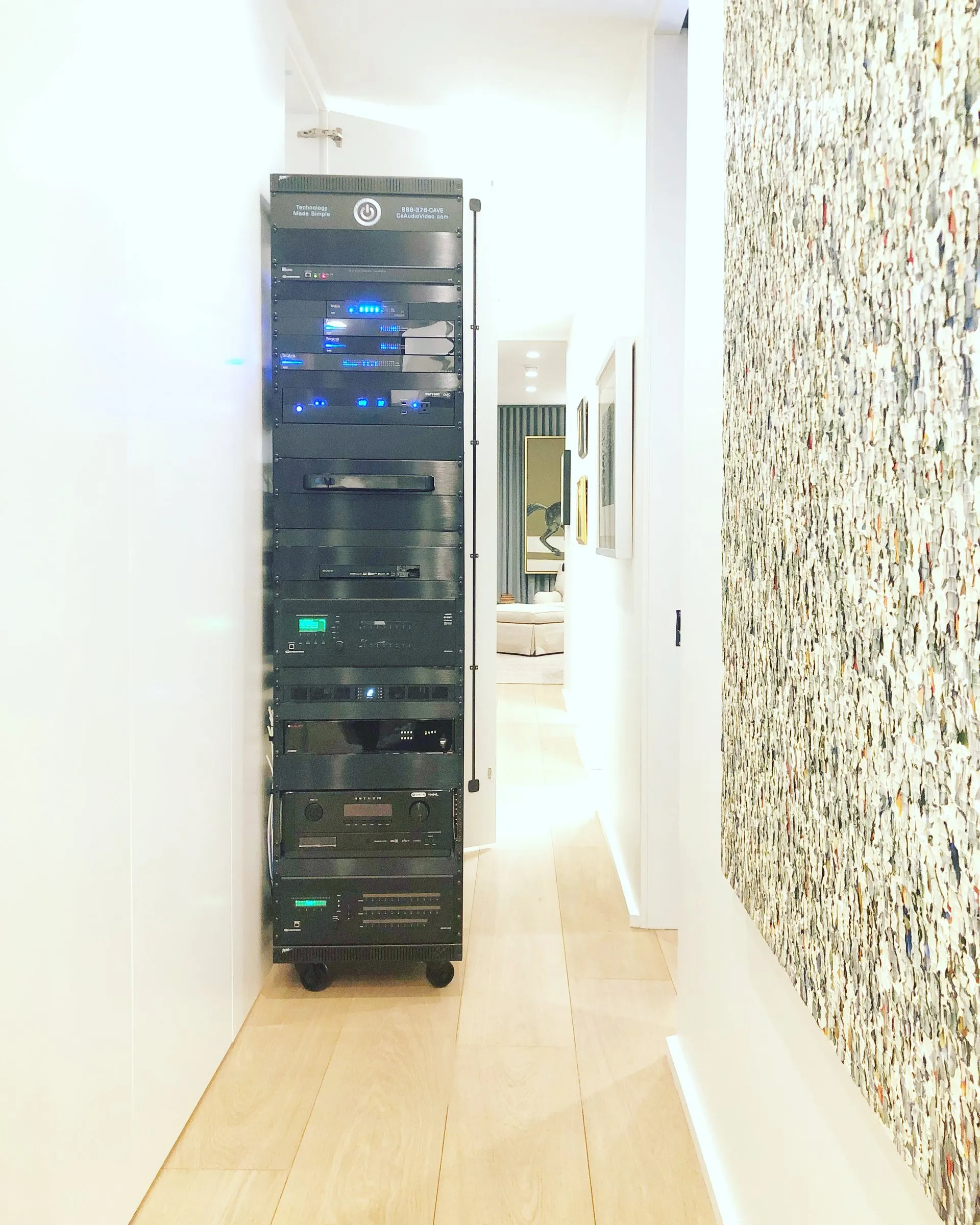 Tall equipment rack standing at the end of a bright gallery hallway